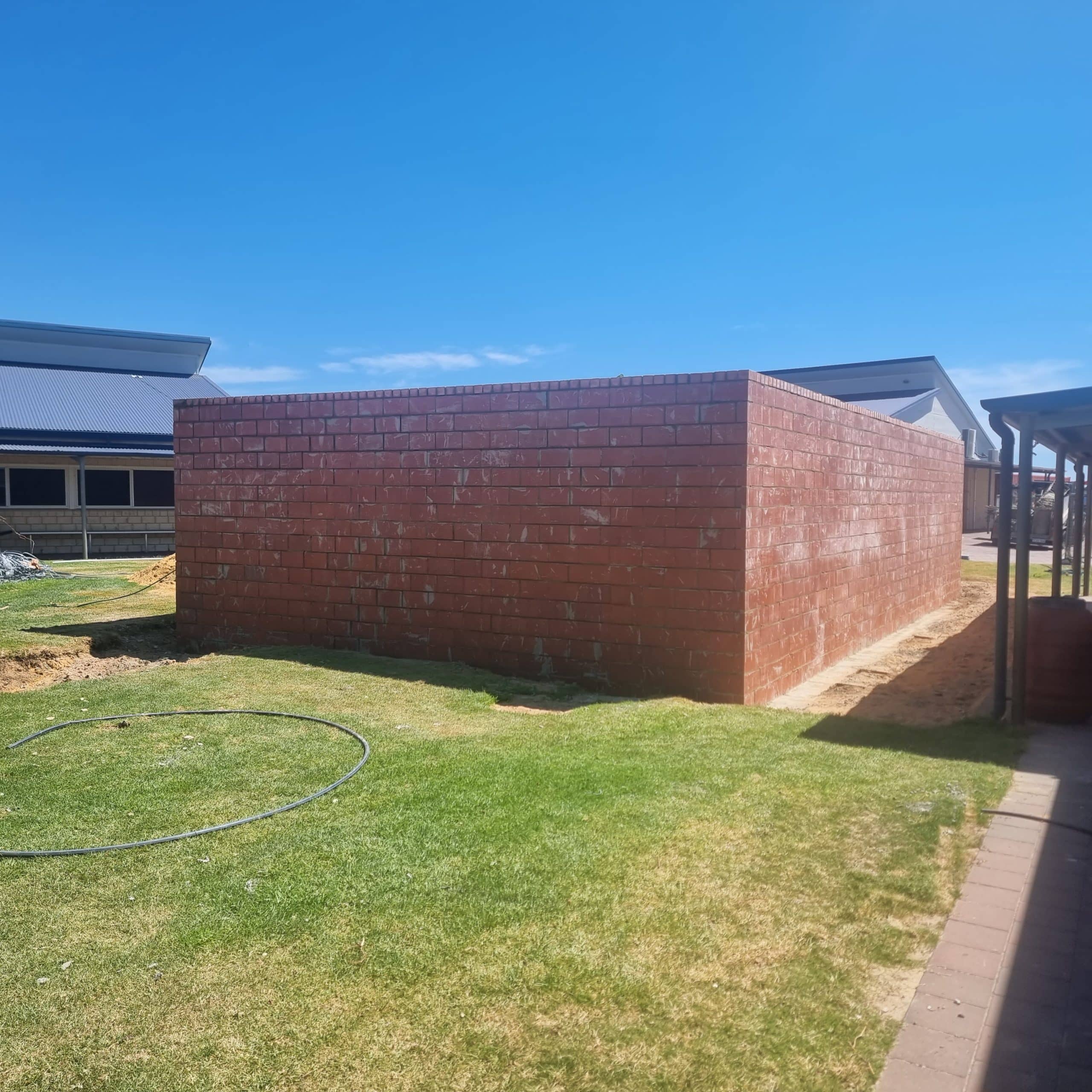 A red brick wall surrounding an outdoor area