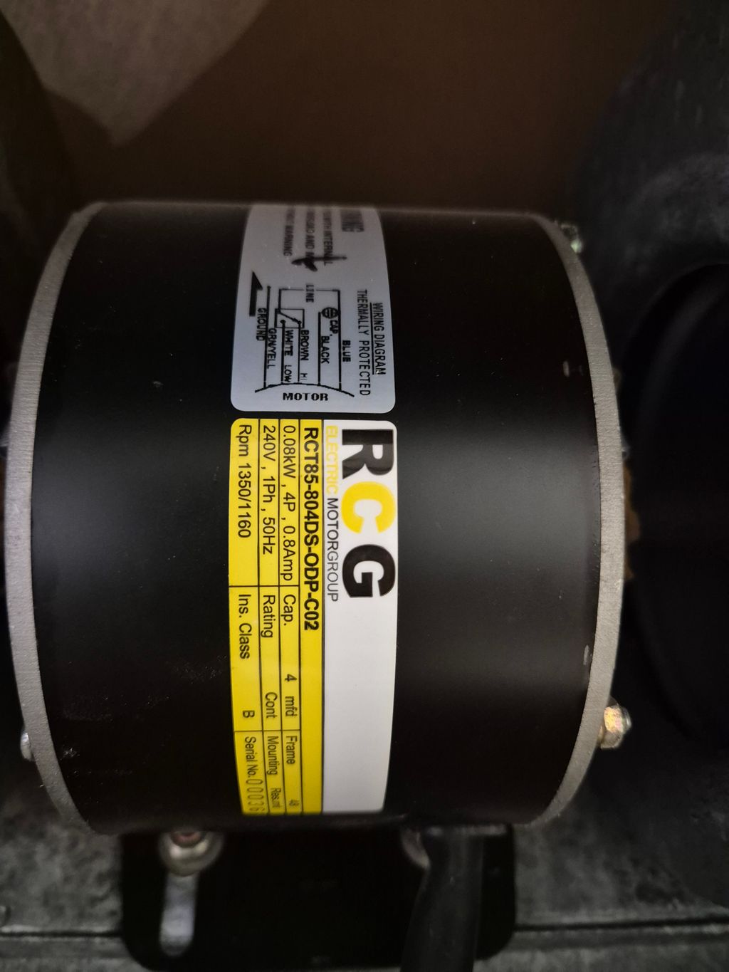 HVAC fan motor with specification label mounted inside an air handling unit.