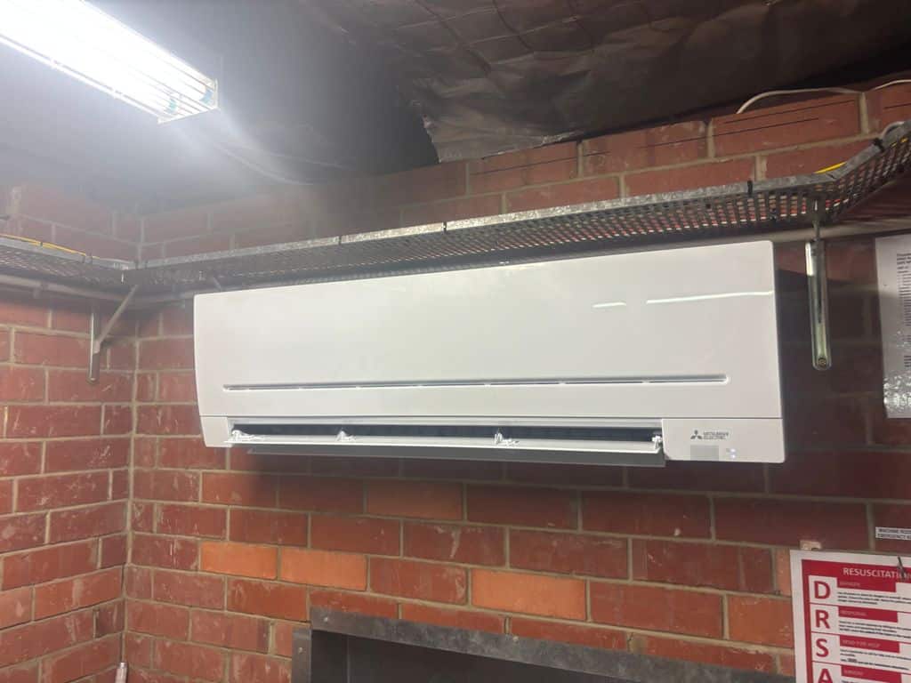 Mitsubishi Electric wall-mounted air conditioning unit installed in a plant room.