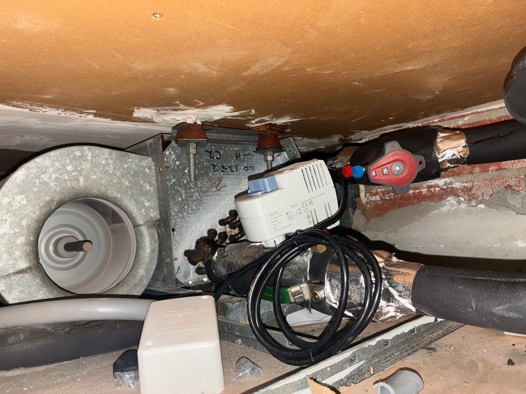 Close-up of a new motorised valve installed on insulated HVAC pipework.