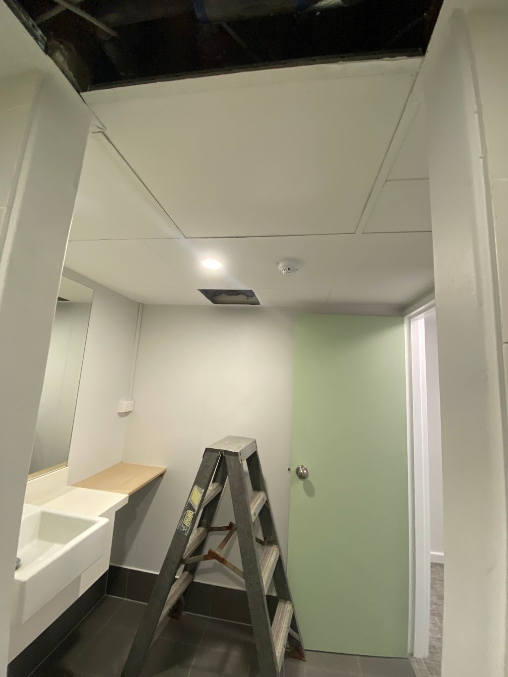 A bathroom with air conditioning being installed