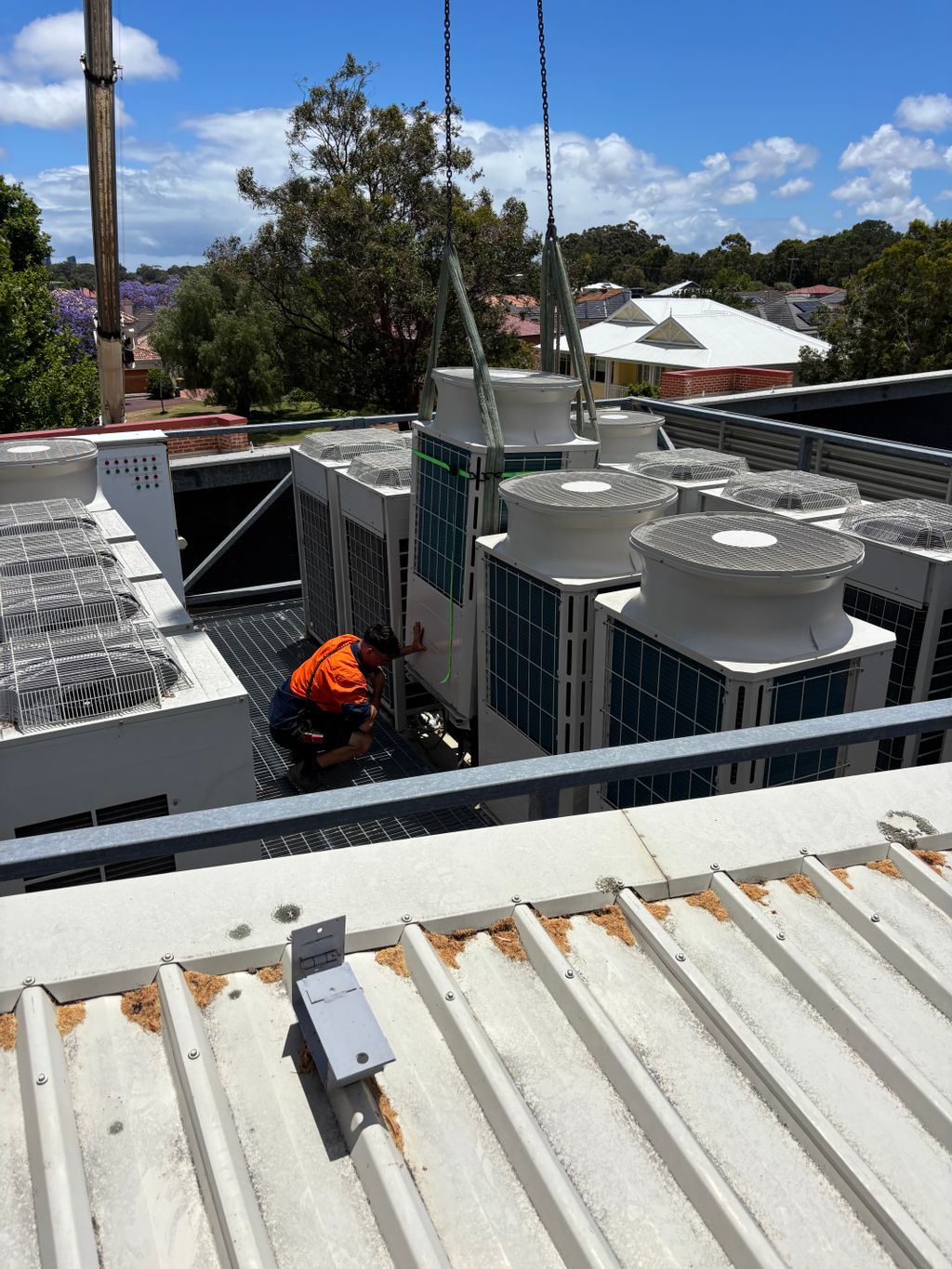 worker installing airconditioner equipment on the roof