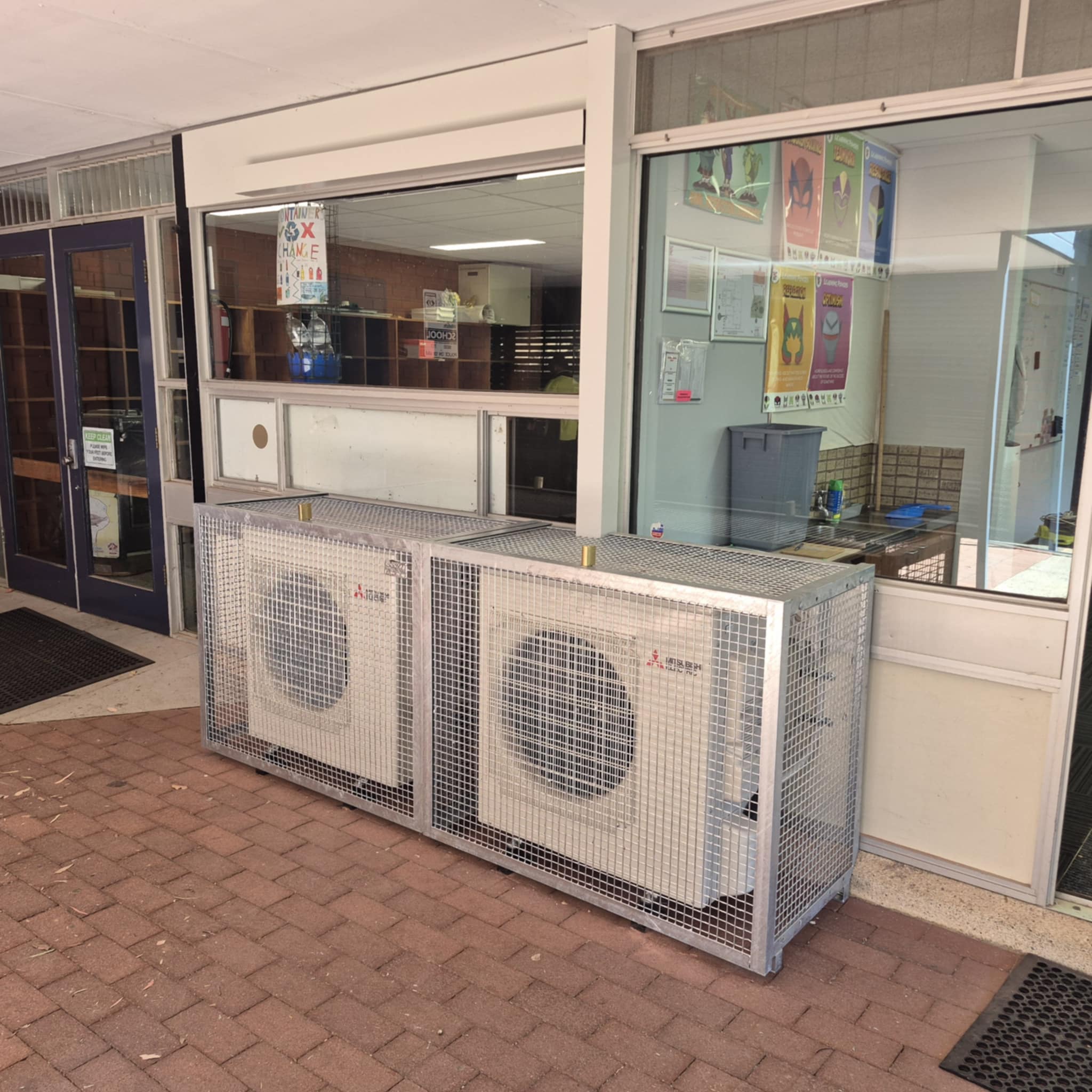 air conditioner outdoor unit mounted on the wall and covered with a metal frame