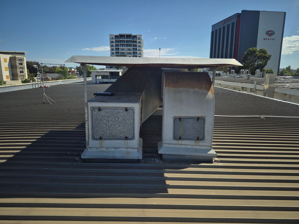 Rooftop exhaust ventilation ductwork before replacement on a commercial building.