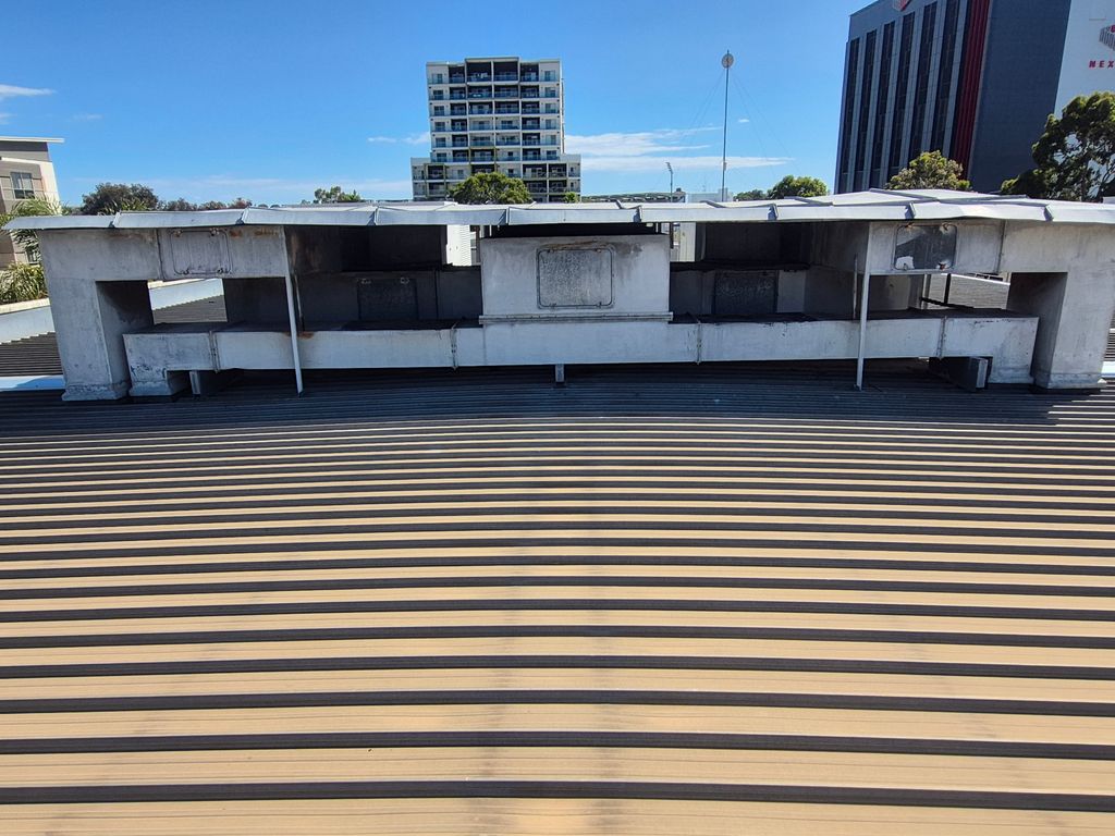 Existing rooftop ventilation plenum showing weathered exhaust ductwork scheduled for replacement.