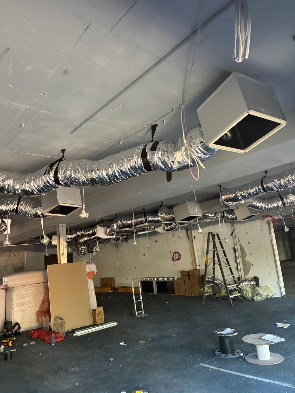 Newly installed insulated flexible ductwork and ceiling diffusers inside a commercial fit-out.