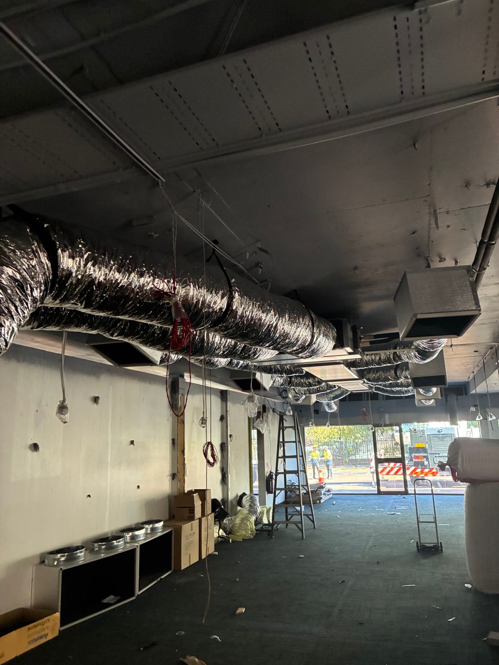 Commercial HVAC ductwork installation in progress with insulated flexible ducts and ceiling outlets.