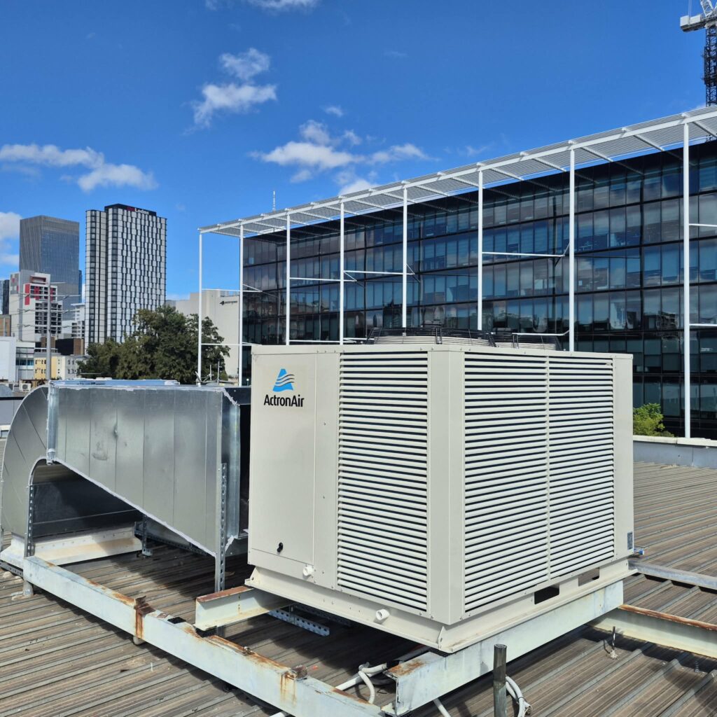 Close-up of a newly installed ActronAir rooftop packaged unit connected to ductwork.