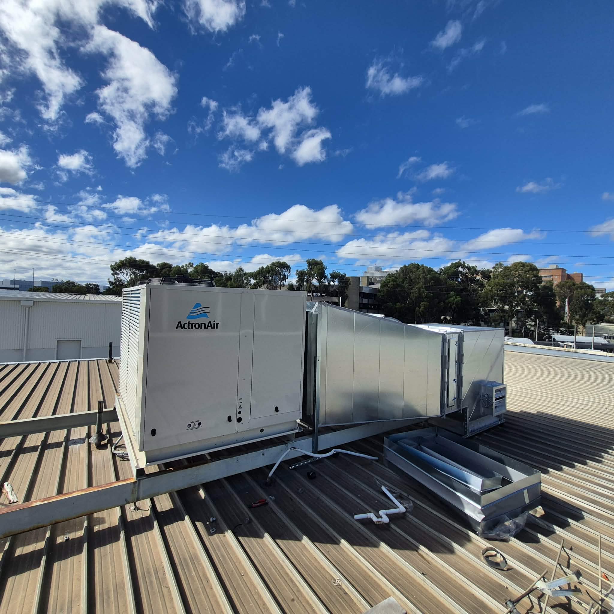 Completed rooftop ActronAir HVAC installation with connected ductwork.