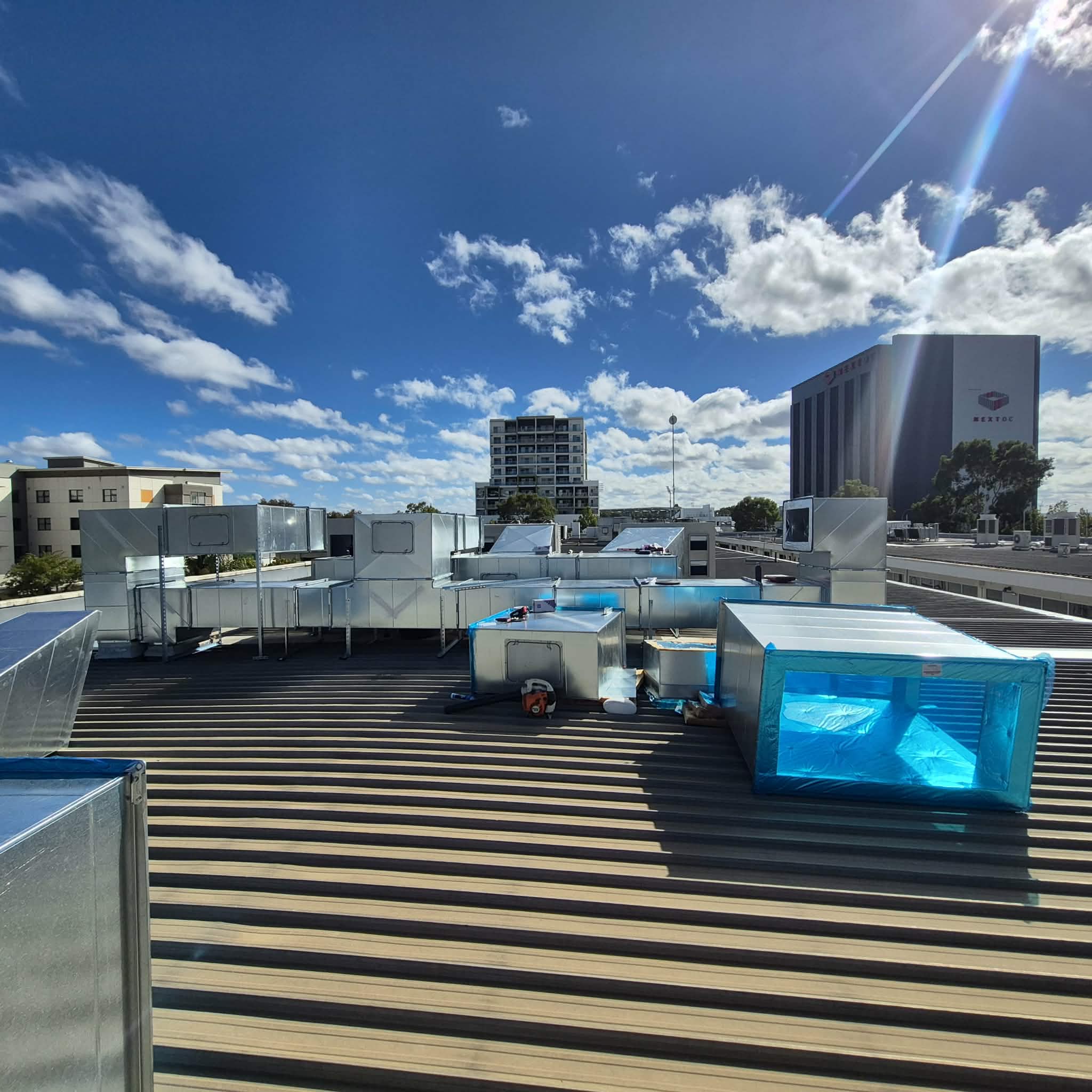 New rooftop ventilation ductwork installed across a commercial roof.